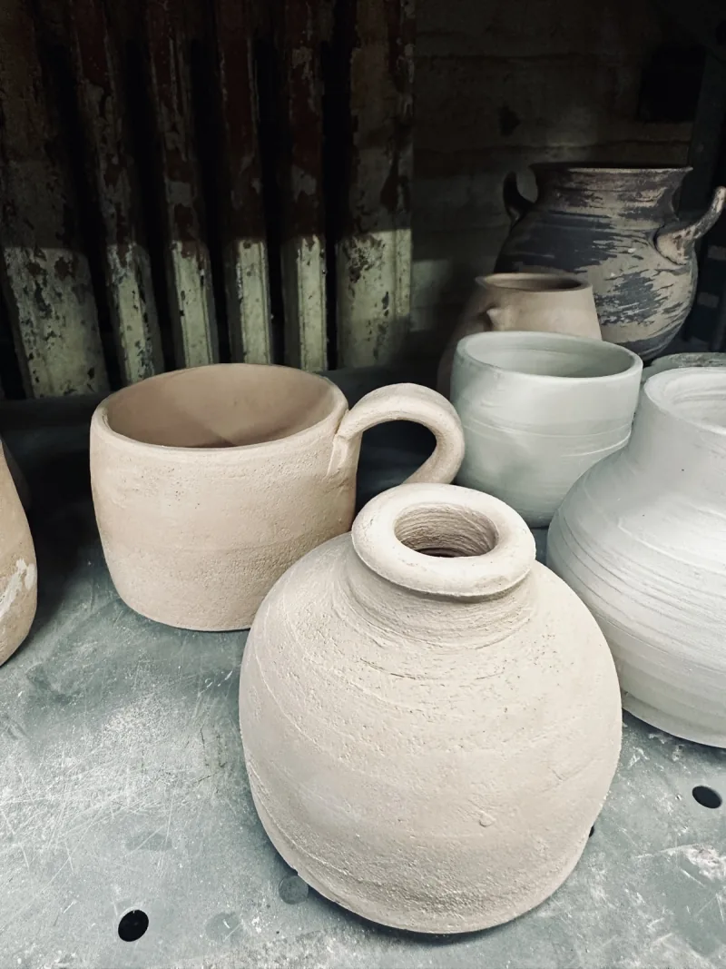 Unfired pottery on the studio shelf